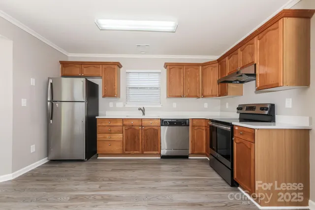 a kitchen with stainless steel appliances granite countertop a refrigerator sink and stove