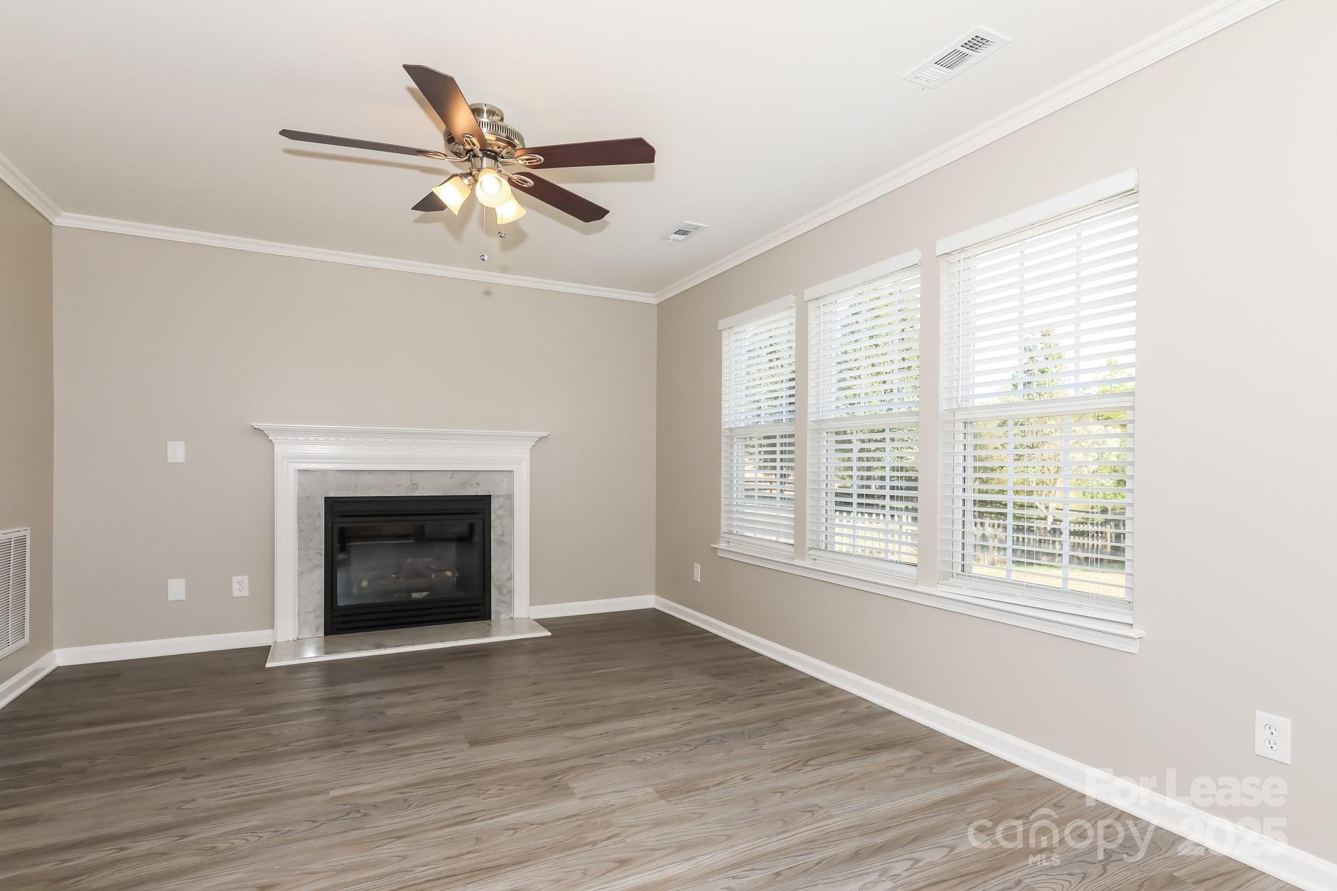 7037 Honey Tree Lane Indian Trail, NC 28079 - Photo 8 of 17 a view of an empty room with wooden floor and a window