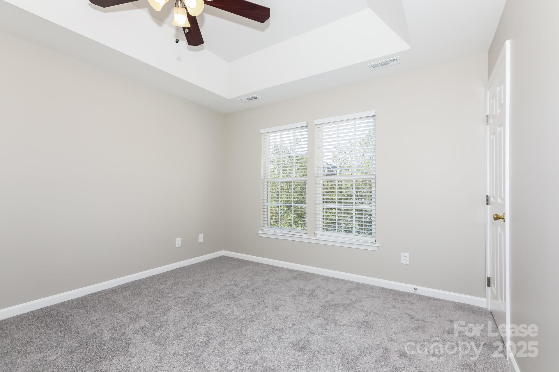7037 Honey Tree Lane Indian Trail, NC 28079 - Photo 9 of 17 an empty room with a window and a ceiling fan