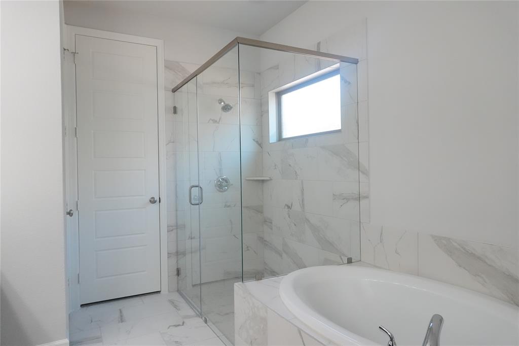 4115 Hudson Street Fate, TX 75087 - Photo 15 of 24 a bathroom with a bathtub and a shower
