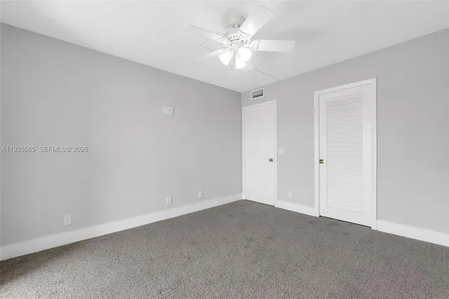 an empty room with a ceiling fan and a window