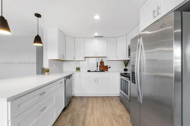 a kitchen with a sink stainless steel appliances and cabinets
