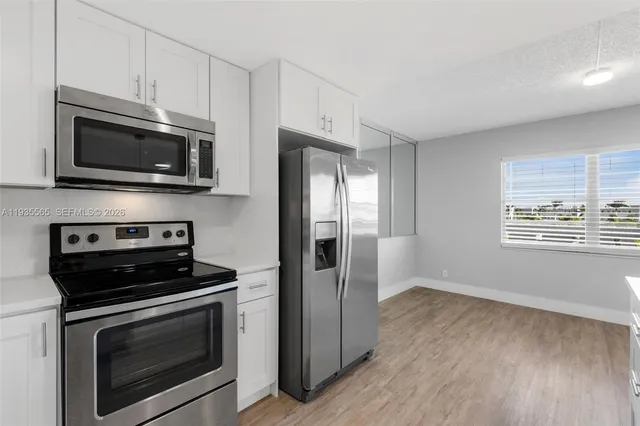 a kitchen with stainless steel appliances a stove microwave and sink