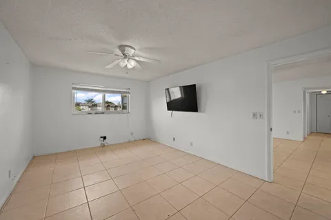 a view of an empty room with a window and a flat screen tv