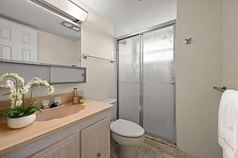 a bathroom with a granite countertop sink toilet and shower