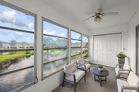 a living room with furniture and a floor to ceiling window