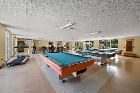 a living room with furniture pool table and a flat screen tv