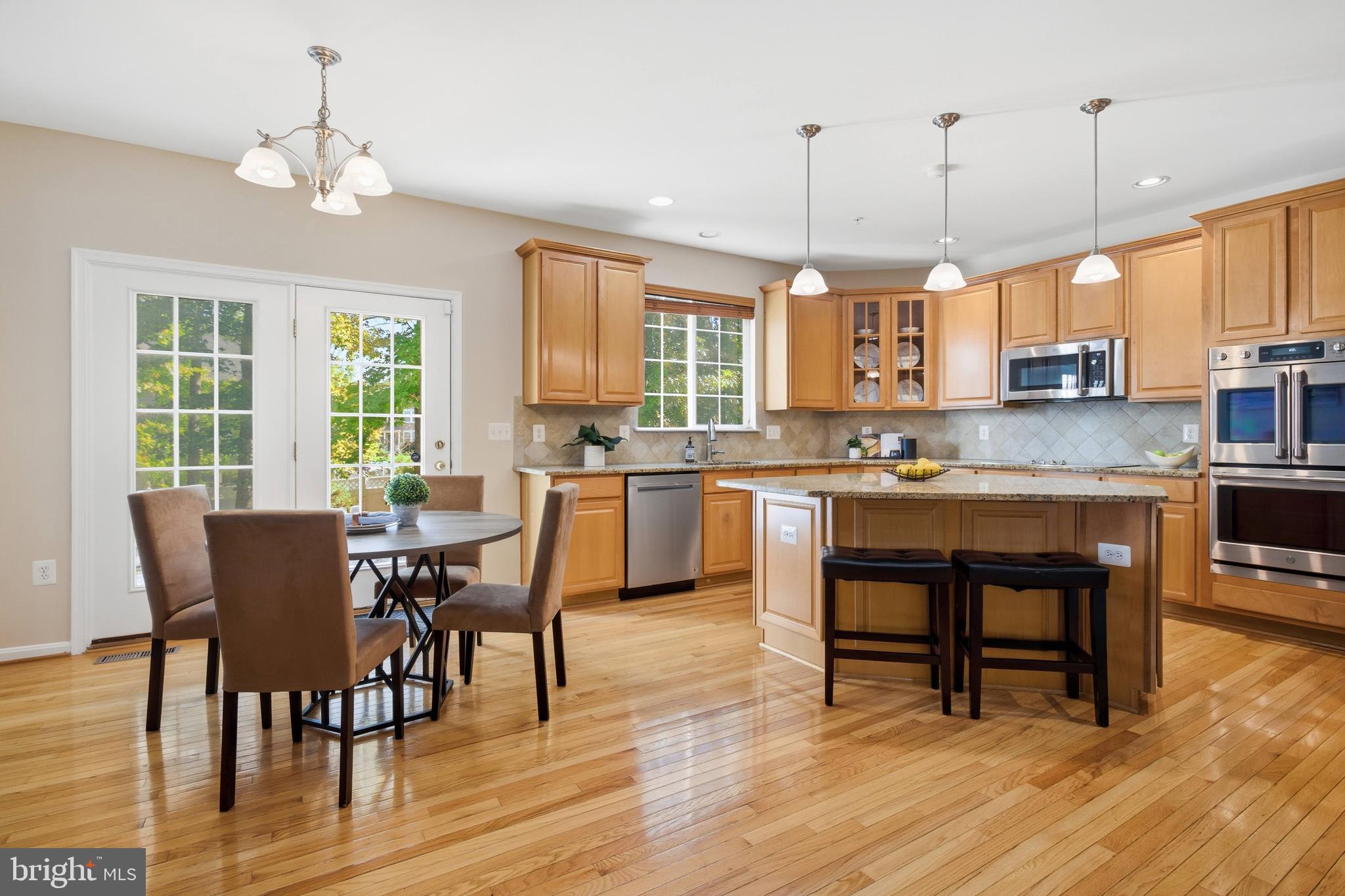 9013 Helmsley Drive Clinton, MD 20735 - Photo 25 of 68 a open dining room with stainless steel appliances kitchen island granite countertop a stove a sink a dining table and chairs