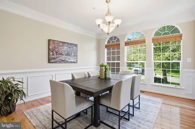 a kitchen with stainless steel appliances kitchen island granite countertop a refrigerator a stove top oven a sink dishwasher and white cabinets with wooden floor