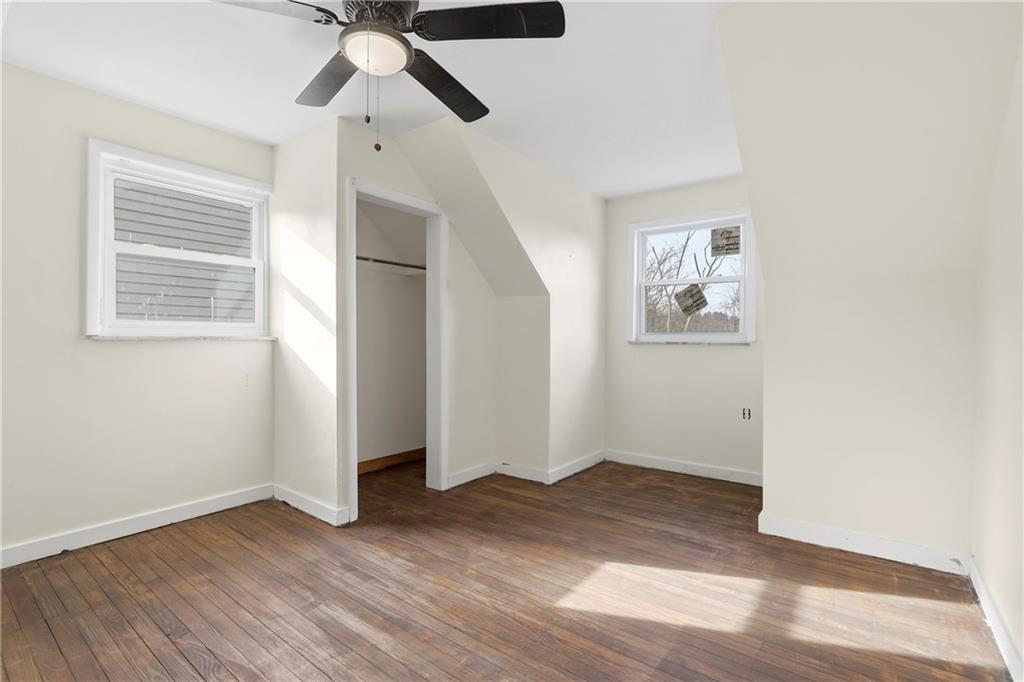 1865 Montour St Extension Coraopolis, PA 15108 - Photo 22 of 41 an empty room with wooden floor chandelier fan and windows