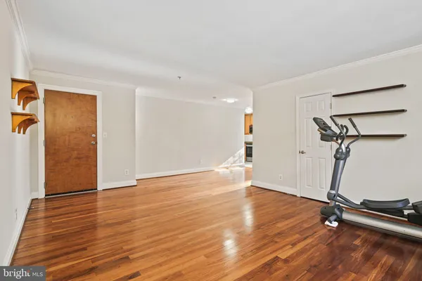 a view of a room with wooden floor and a ceiling fan