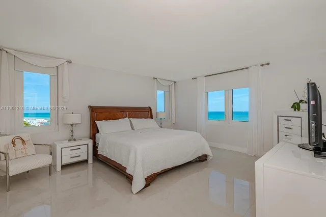 a bedroom with a bed and flat tv screen on the dresser