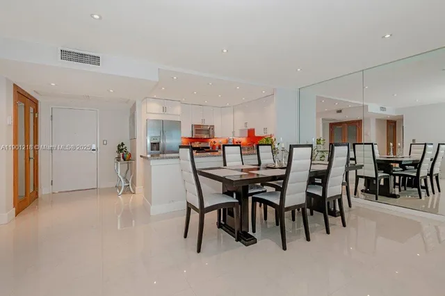 a dining room with furniture and a dining table with kitchen view