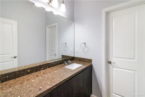 a bathroom with a granite countertop sink and a mirror