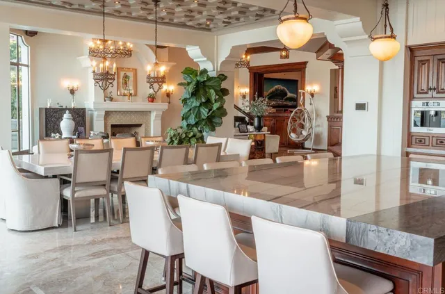 a dining room with fireplace chandelier and furniture