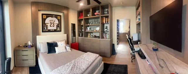 a bedroom with a bed and a flat tv screen on the dresser