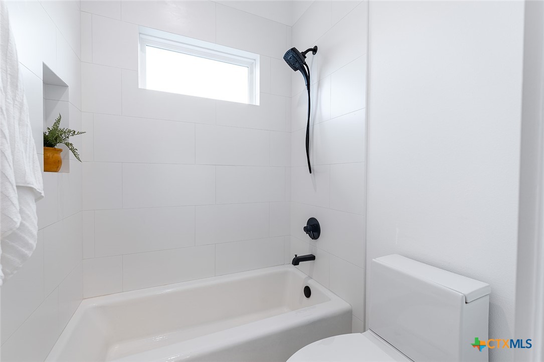 477 Willow Moon Ranch Road Crawford, TX 76638 - Photo 27 of 40 a bathroom with a bathtub a toilet and a shower