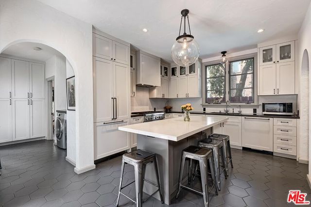 a kitchen with white cabinets and refrigerator