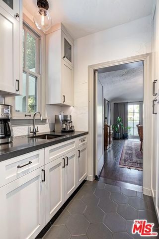 a kitchen with granite countertop white cabinets and white appliances