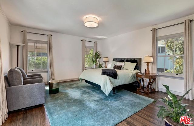 a bedroom with bed couch and window