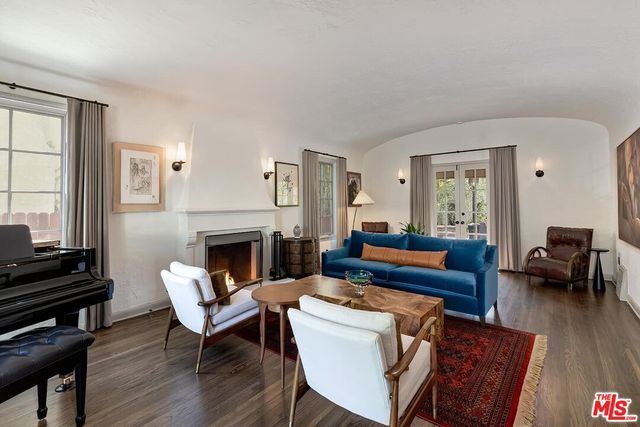 a living room with furniture a fireplace and a piano