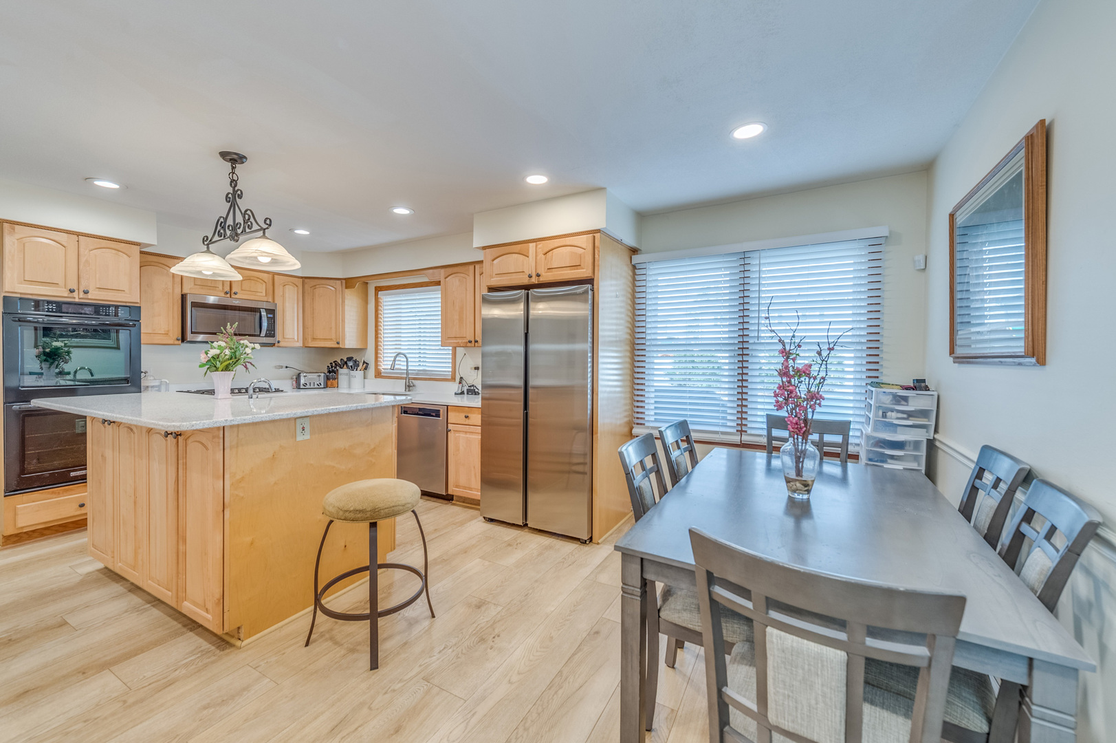 1716 Beech Road Mount Prospect, IL 60056 - Photo 10 of 28 a kitchen with stainless steel appliances granite countertop a dining table chairs and a refrigerator