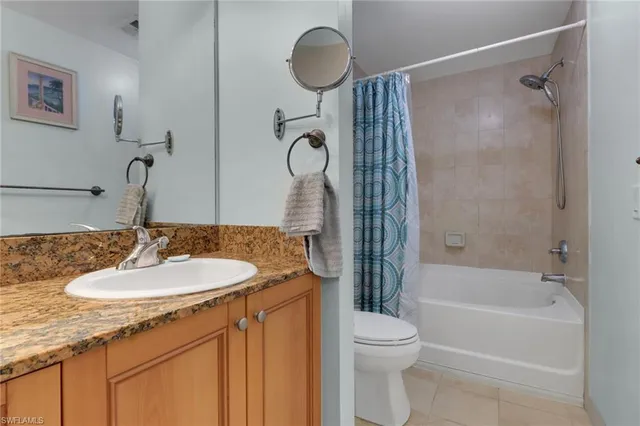 a bathroom with a granite countertop sink toilet a mirror and shower