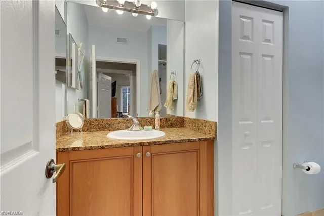 a bathroom with a granite countertop sink and a mirror