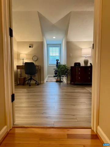 a view of a white house with a large tree with yard