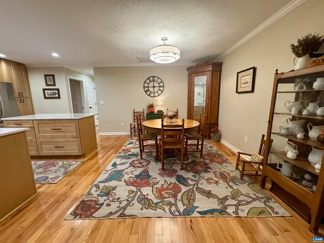 a living room with stainless steel appliances kitchen island granite countertop furniture wooden floor and a kitchen view