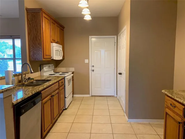 a kitchen with a sink a stove cabinets and a window
