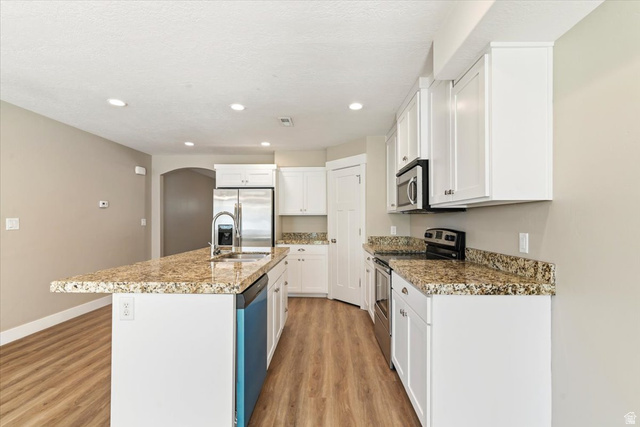 857 225 South Springville, UT 84663 - Photo 7 of 23 Kitchen featuring wood-finish flooring and white cabinetry