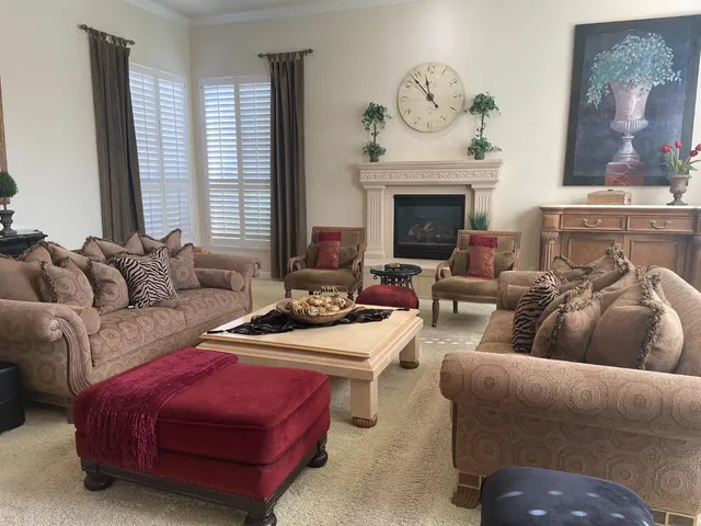 a living room with furniture a fireplace and a large window