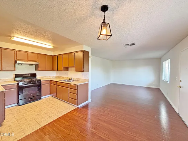 a kitchen with stainless steel appliances granite countertop a stove and a wooden floors