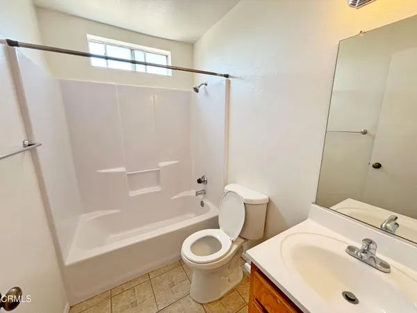 a white toilet sitting next to a bath tub