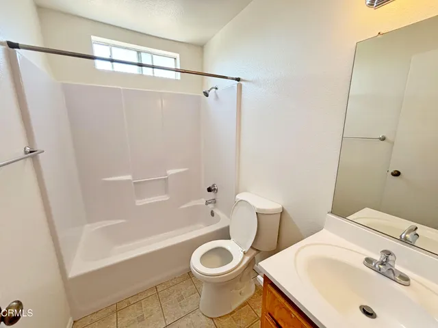 a white toilet sitting next to a bath tub