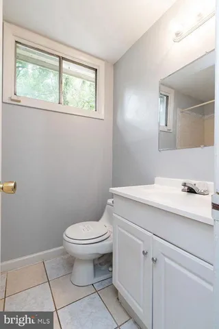 a bathroom with a sink a toilet and a window