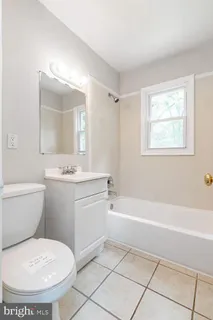 a bathroom with a granite countertop toilet a sink and mirror