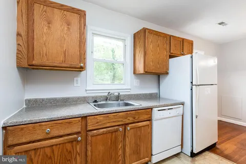 a kitchen with stainless steel appliances granite countertop a sink cabinets and a refrigerator