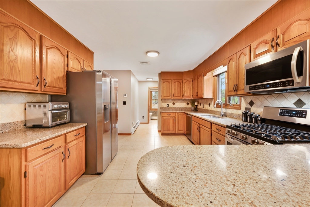 206 Olde Forge Road Hanover, MA 02339 - Photo 5 of 42 a kitchen with stainless steel appliances granite countertop a stove top oven a sink dishwasher a refrigerator and cabinets with wooden floor