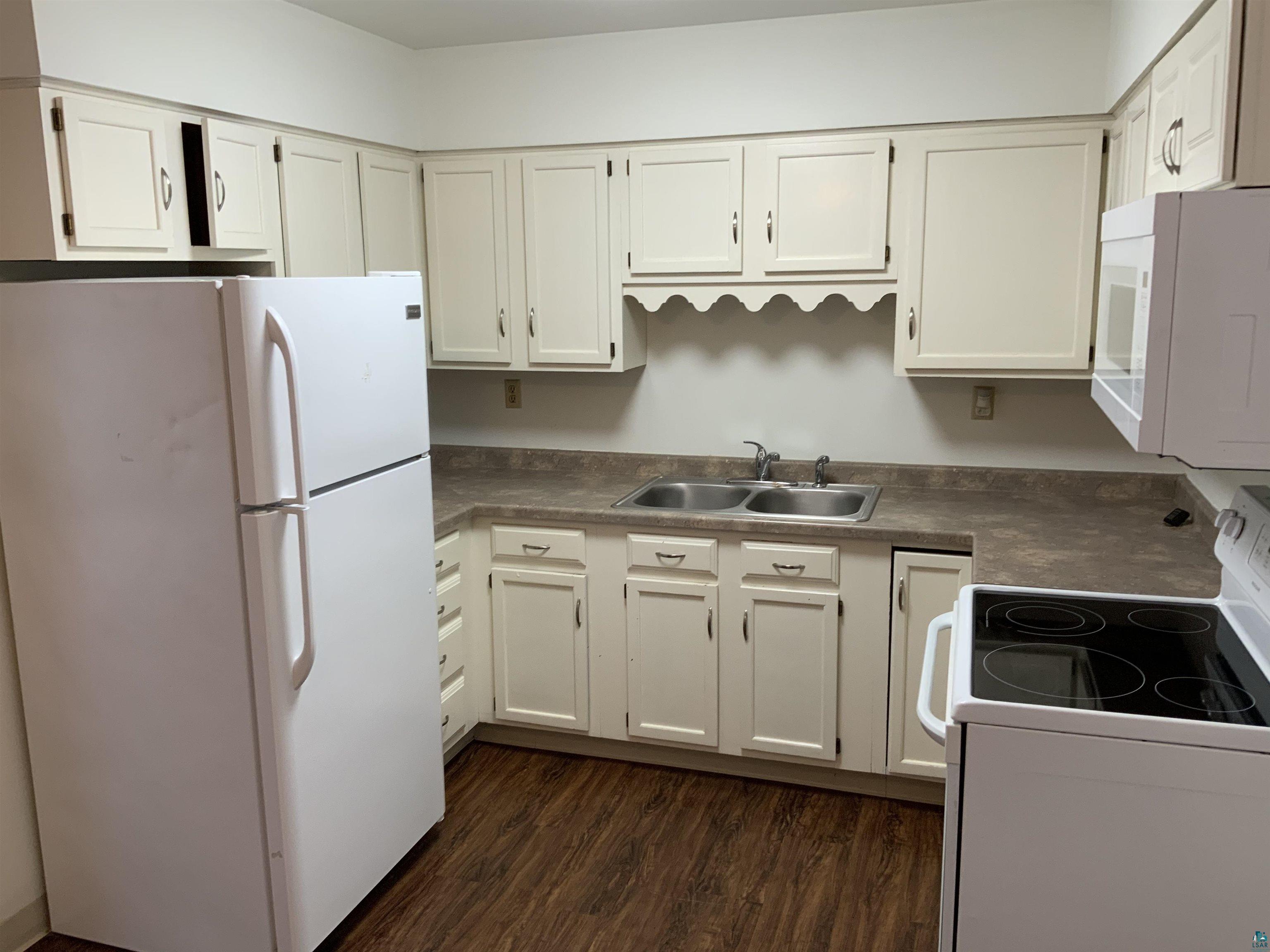 850 Spring Lake Road Cloquet, MN 55720 - Photo 12 of 18 Kitchen featuring white cabinets, dark wood-type flooring, white appliances, and sink