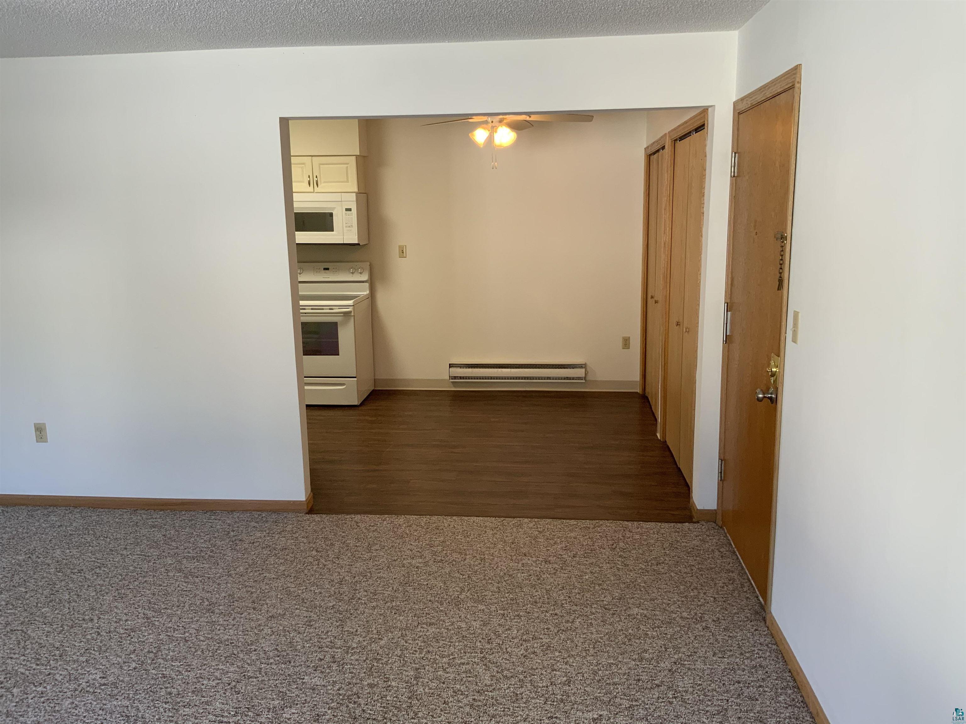 850 Spring Lake Road Cloquet, MN 55720 - Photo 14 of 18 Corridor featuring a textured ceiling, a baseboard heating unit, and dark wood-type flooring