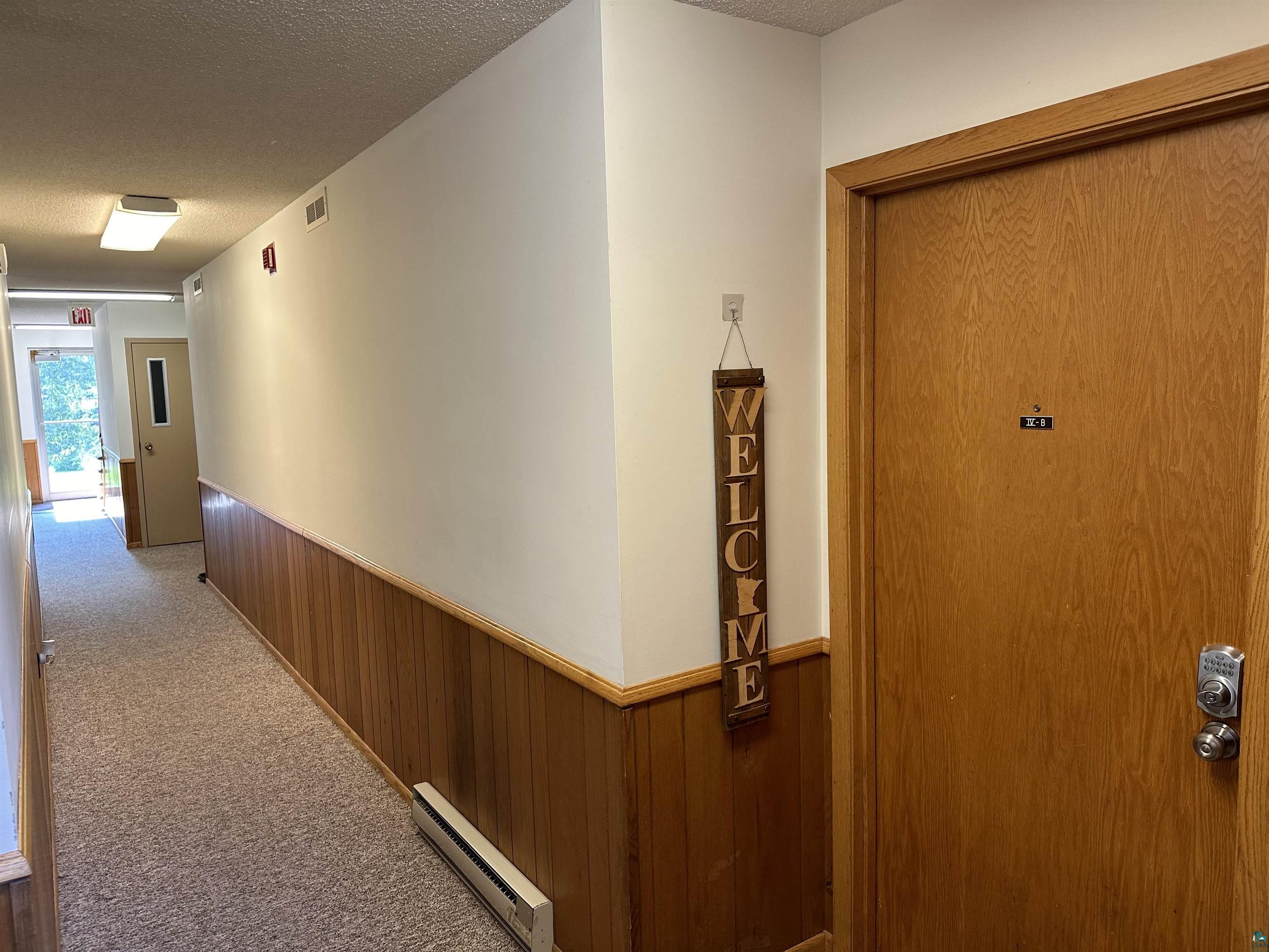 850 Spring Lake Road Cloquet, MN 55720 - Photo 8 of 18 Hallway with a textured ceiling, baseboard heating, and carpet flooring