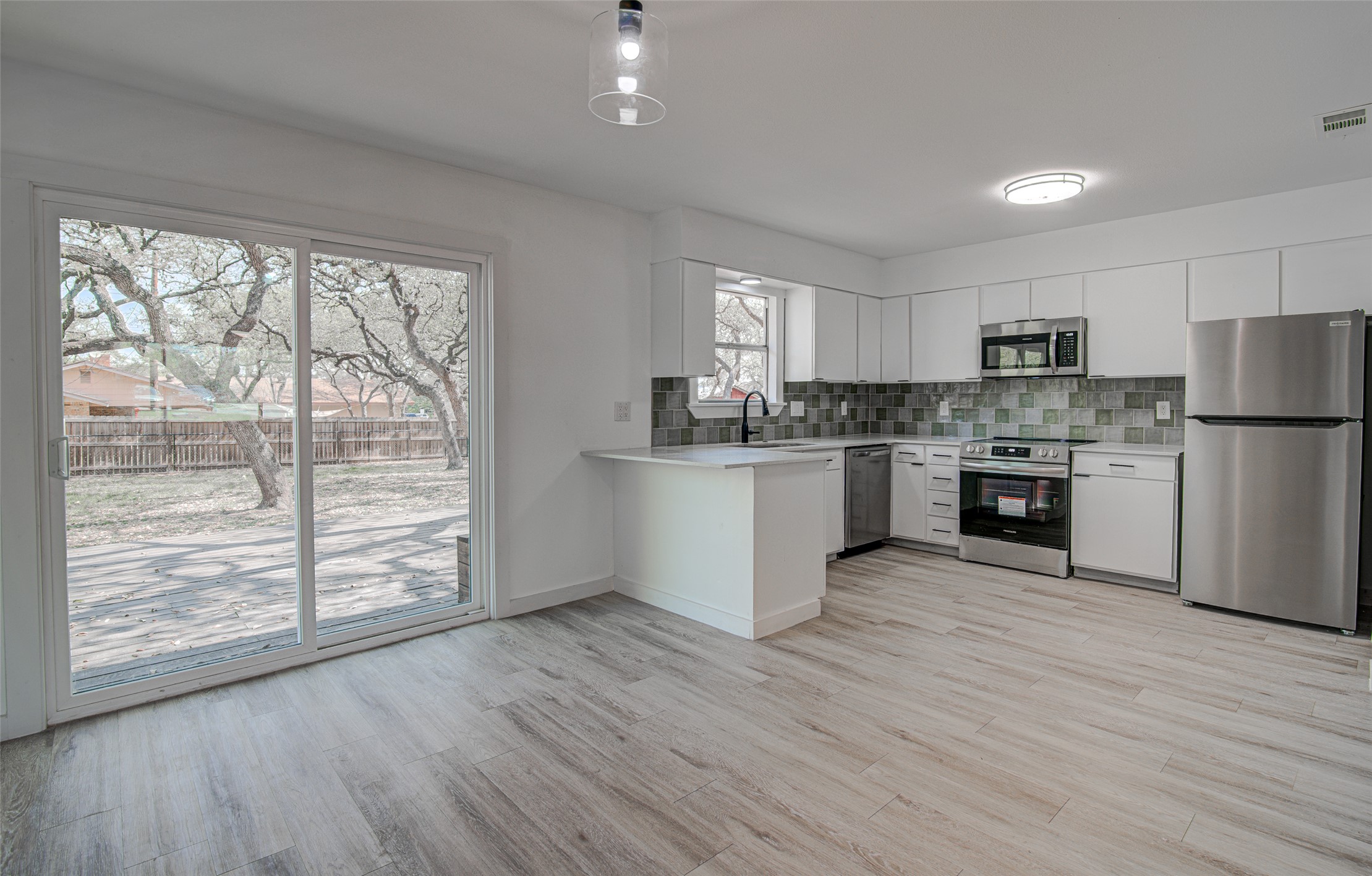 207 Haley Road Johnson City, TX 78636 - Photo 10 of 31 A sleek, open-concept kitchen with backyard access, ideal for modern living.