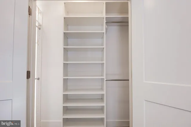 a view of a hallway with wooden floor and stairs