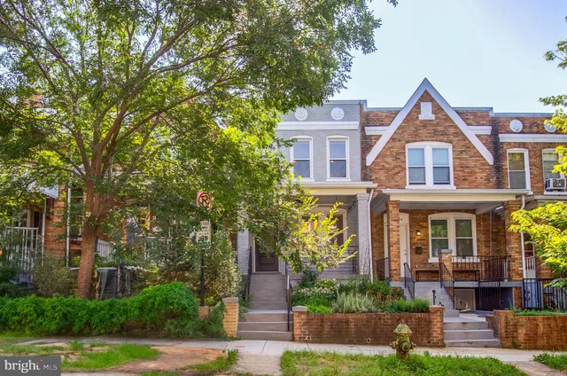 a front view of a house with a yard and a garden