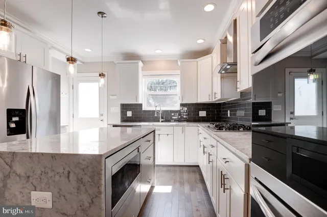 a kitchen with stainless steel appliances granite countertop a sink and a microwave