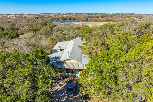 an aerial view of a house with a yard and lake view