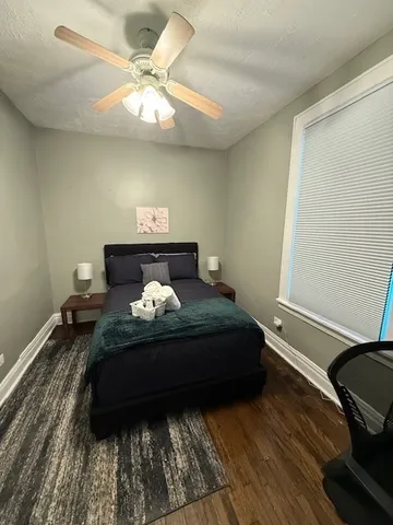 a bedroom with a bed and a ceiling fan