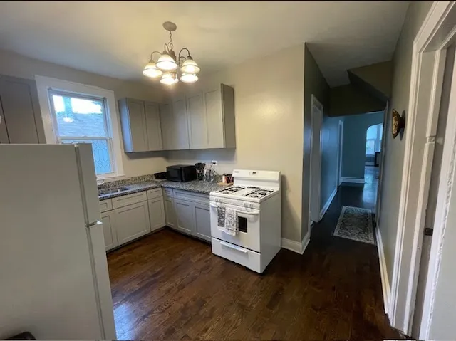 a kitchen with white cabinets and white appliances